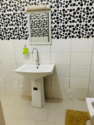 een badkamer met een witte wastafel en een raam bij TerraNova IMMO in Mbour