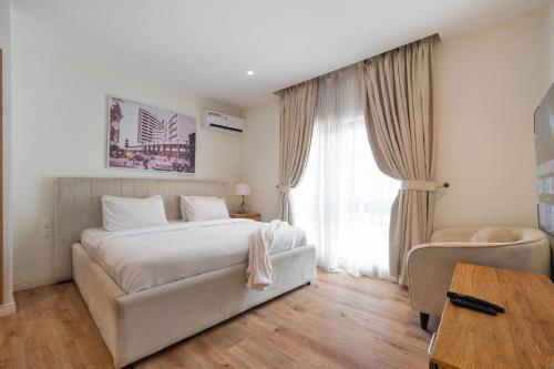 a bedroom with a white bed and a window at Aima Apartments in Lekki