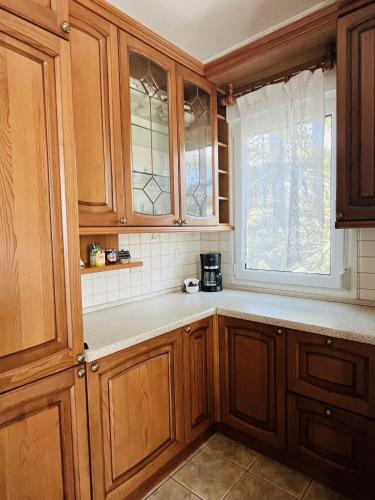 a kitchen with wooden cabinets and a window at Villa Di Costa in Nea Skioni