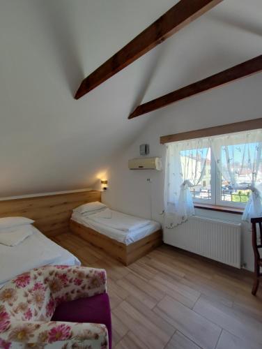 a bedroom with two beds and a chair and a window at Pensiunea Buon Gusto Sibiu-motorcyle friendly,city center in Sibiu