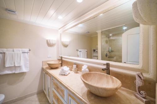 a bathroom with a sink and a large mirror at Glitter Bay Apartment 104 in Saint James