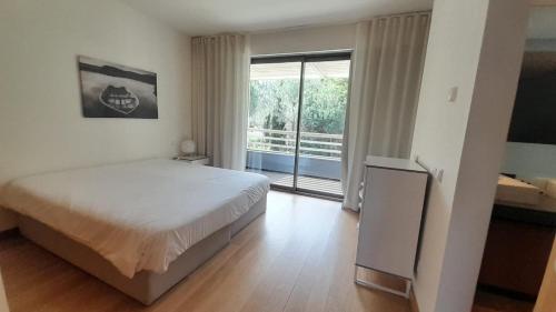 a bedroom with a bed and a large window at Tróia Oasis Villa in Troia