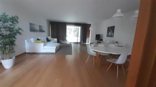 a living room with a white couch and a table at Tróia Oasis Villa in Troia