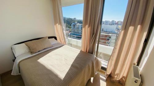a bedroom with a bed and a large window at Viabo in Viña del Mar