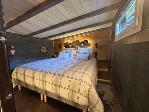une chambre avec un grand lit dans une pièce dans l'établissement TiNY HOUSE LE CHALET, à Échenoz-la-Méline