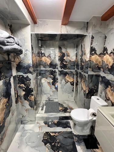 a bathroom with a black and white marble wall at Arius King in Satu Mare