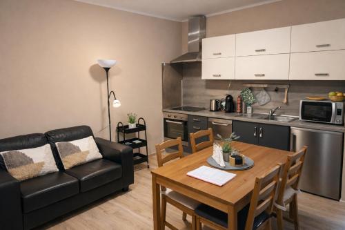 a living room with a table and a couch and a kitchen at Apartment Riviera 13 Lipno in Lipno nad Vltavou