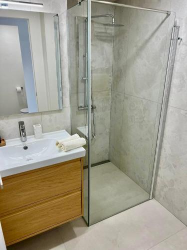 a bathroom with a glass shower and a sink at Sea View Apartment - Residence Les Sablettes in Menton