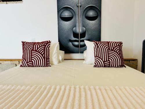 a bed with two pillows with a face on the wall at Largo de Santa Ana in Cadaval