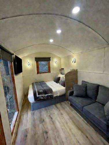 a bedroom with a bed and a couch in a trailer at Rectory Hideaway in Reedham