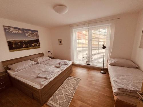 a bedroom with a large bed and a window at Apartmán Mařinka in Říčky