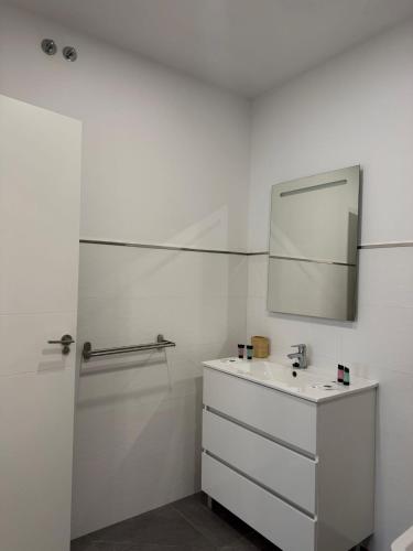a white bathroom with a sink and a mirror at Bruma in Vilagarcia de Arousa