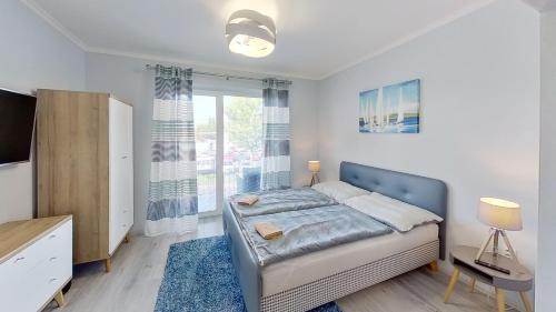 a bedroom with a bed and a large window at Penzión Mika in Štúrovo