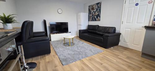 a living room with black leather chairs and a television at Reardon near warwick hospital, free parking, fast wifi, sleeps 5 in Warwick