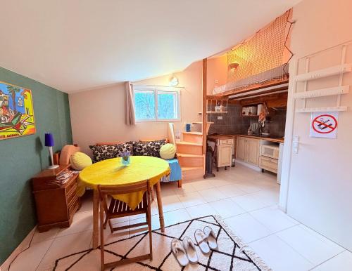 a living room with a table and a kitchen at Studio Piscine en Drôme Provençale Repas Asiatique sur demande in Taulignan