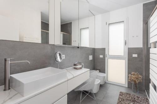 a white bathroom with a sink and a mirror at Luxury beach front in Torre Grande