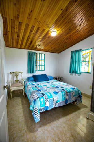 a bedroom with a bed and a wooden ceiling at Finca La Molienda, espléndido Mirador del Quindio in Circasia