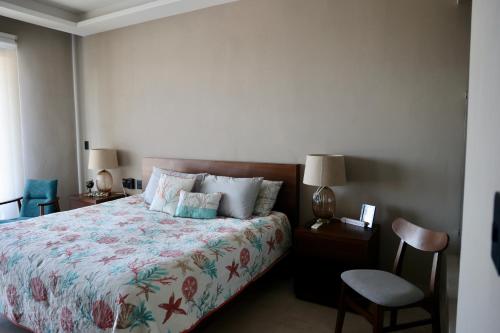 a bedroom with a bed and a chair at Deck 17 in Cozumel