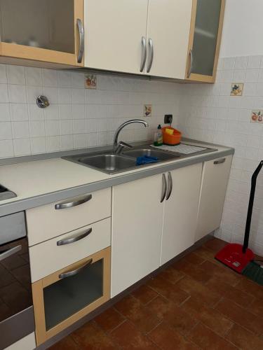 a kitchen with white cabinets and a sink at Tuscany Location in Marta