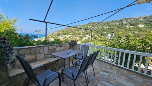a table and chairs on a balcony with a view at Raptis House in Karavostamo