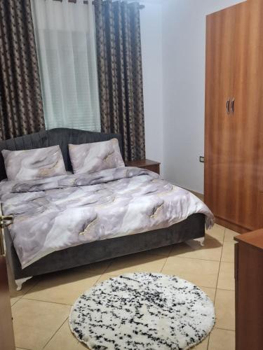a bedroom with a bed and a rug on the floor at Elegant Apartment City Center in Fier