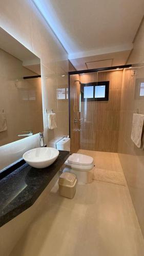 a bathroom with a sink and a toilet and a tub at Paraná Beach Apart Hotel in Encarnación