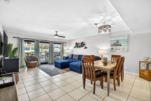 a living room with a table and a blue couch at 5 Star 30 Steps from Beach l 3m Walk to Rest & Shops in Clearwater Beach