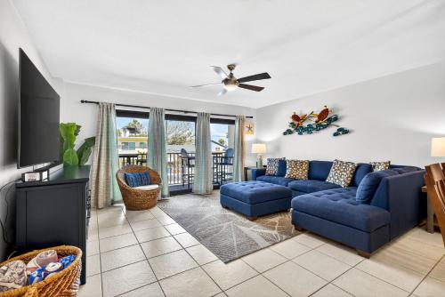 a living room with a blue couch and a tv at 5 Star 30 Steps from Beach l 3m Walk to Rest & Shops in Clearwater Beach