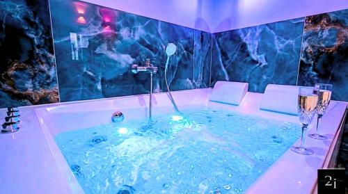 a bath tub with two wine glasses in it at LE 21 - Suite SPA Premium - Jacuzzi Privatif & Vue Rhône in Vienne