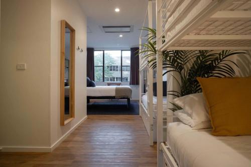 a bedroom with a white bed and a mirror at Little Drifter Canberra in Canberra