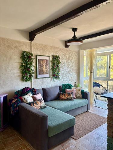 a living room with a blue couch in a room at Nibelungos House - Alojamiento artesanal Whimsical frente al Pantano de San Juan - 3 min a pie in San Martín de Valdeiglesias