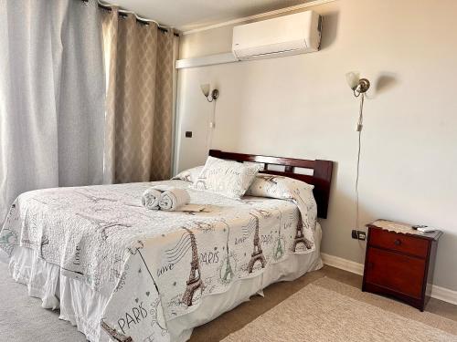 a bedroom with a bed with a white blanket at Apartamento Vista Buena in Talca