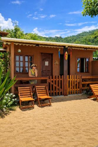 a woman standing on the porch of a cabin at Suítes Sol e Mar - Pé na Areia- Ilha Grande in Angra dos Reis