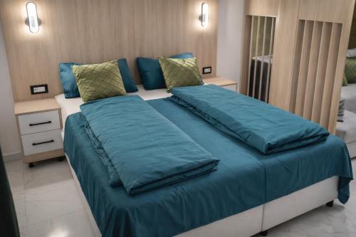 a large bed with blue sheets in a bedroom at Avis 2 in Igalo