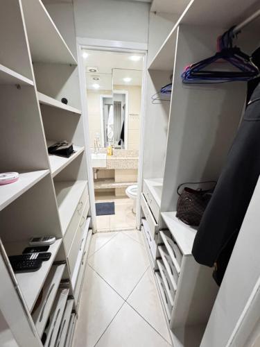 a walk in closet with white shelves and a bathroom at Hotel Platinum - Landscape Luxo - in Fortaleza