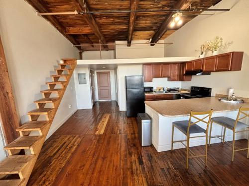 a kitchen with a staircase leading up to a loft at 420 Friendly Industrial Loft Near Downtown Detroit in Detroit