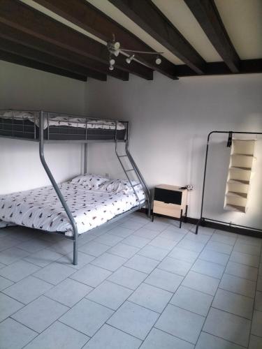 a bedroom with two bunk beds and a tiled floor at Maison de charme solognote in Neung-sur-Beuvron