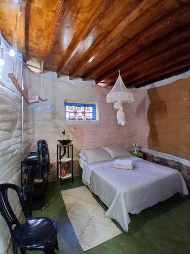 a bedroom with a bed and a table and chairs at Pátio FlorAção in Igatu
