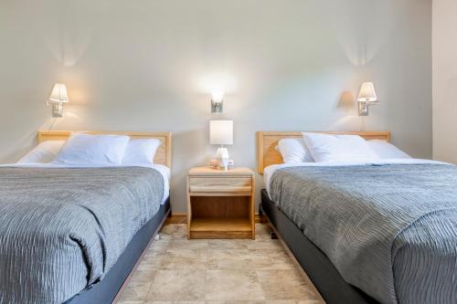 two beds sitting next to each other in a bedroom at Homeport Motel in Lunenburg