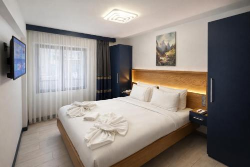 a bedroom with a large bed with white sheets at VAMA TAKSİM Hotel in Istanbul