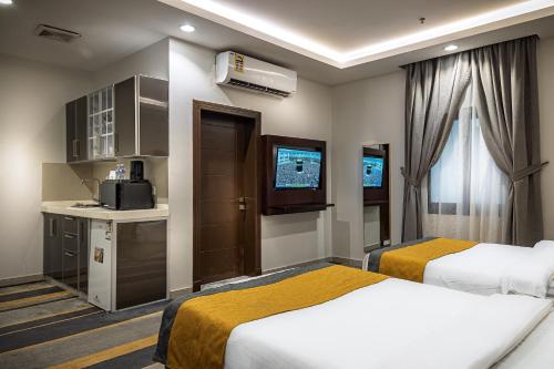 a hotel room with two beds and a kitchen at دار ود للشقق المخدومة Dar Wed in Jeddah