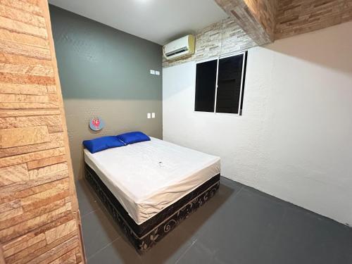 a small bedroom with a bed in the corner at Casa Espaço Gaibu in Cabo de Santo Agostinho