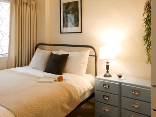 a bedroom with a bed with a dresser and a lamp at Atelier7419 Songpa in Seoul
