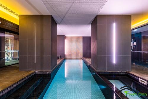 a swimming pool in a building with purple walls at High level on 42th floor 2BR 1BA Balcony Pool in Melbourne