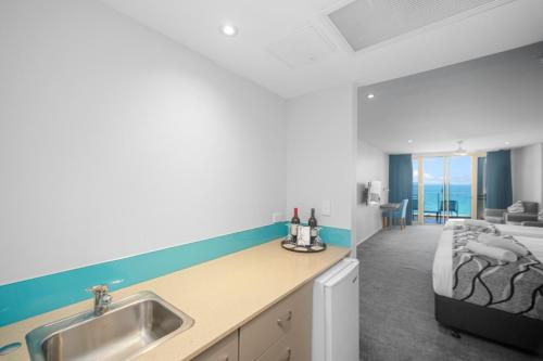 a kitchen with a sink and a bed in a room at The Dorsal Boutique Hotel in Forster