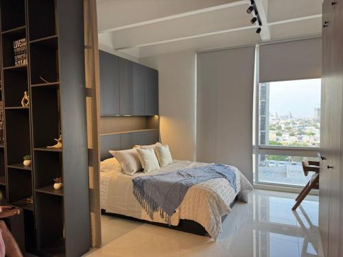 a bedroom with a bed and a large window at Luxury loft for 2 to 4 people in Monterrey