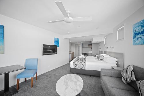 a bedroom with a bed and a couch and a table at The Dorsal Boutique Hotel in Forster