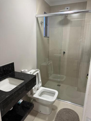 a bathroom with a shower and a toilet and a sink at Meu cantinho in Dourados