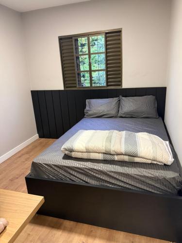 a bedroom with a bed with a black headboard at Meu cantinho in Dourados