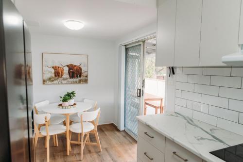 a kitchen with a table and chairs in a kitchen at The Retreat on Piper in Tamworth